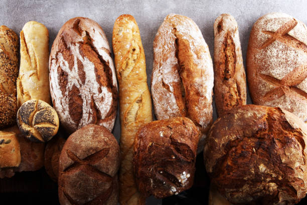 istock Assortment of baked bread and bread rolls on stone table background 1135129201