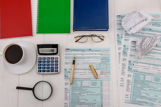 istock Tax form with calculator and coffee on table 1135130234