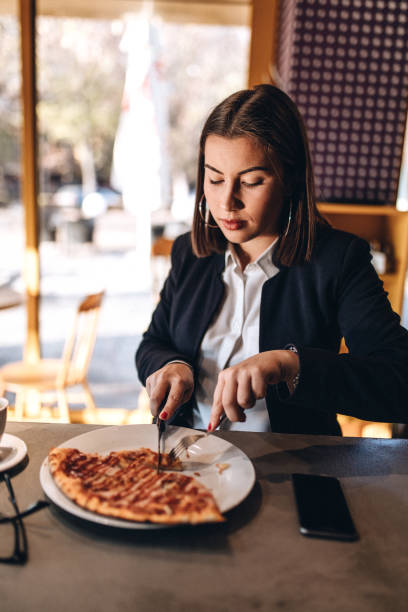 istock Young woman enjoying pizza and coffee 1135131421