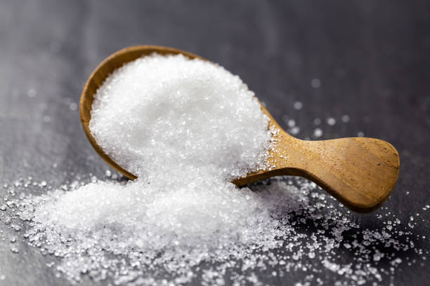 istock Sugar on a wooden spoon On a black background 1135133028
