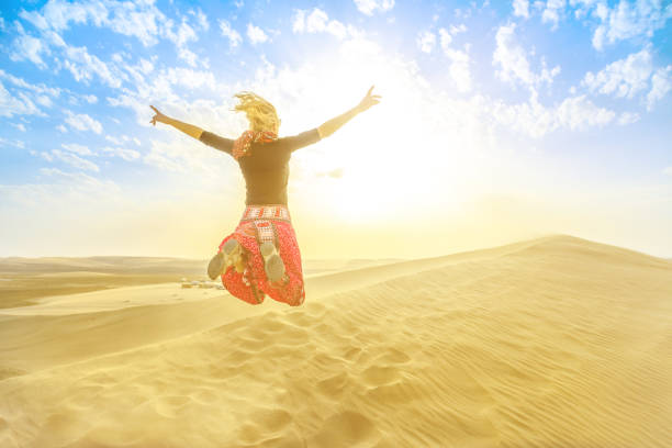 istock Woman jumping in Qatar desert 1135136561