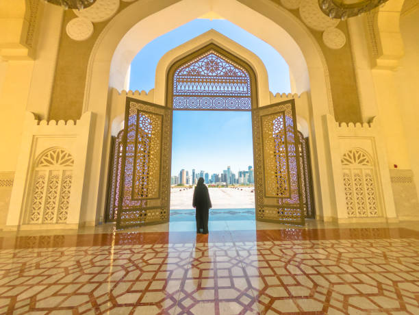 Woman at Mosque Doha Woman with abaya dress looks at views of skyscrapers of Doha West Bay skyline outdoors State Grand Mosque in Doha, Qatar, Middle East, Arabian Peninsula. grand mosque photos stock pictures, royalty-free photos & images