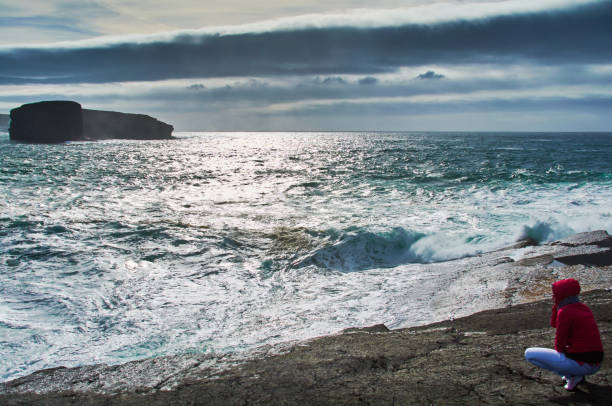 girl at stormy cliffs of kilkee in ireland county clare. tourist destination - kilkee imagens e fotografias de stock