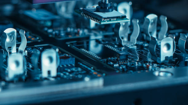 istock Close-up Macro Shot of Electronic Printed Circuit Board Being Assembled with Automated Robotic Arm, Surface Mounted Technology Connecting Microchips, Transistors, Capacitors to the Motherboard. 1135140230