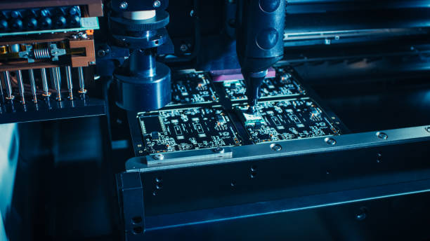 istock Factory Machinery at Work: Printed Circuit Board Being Assembled with Automated Robotic Arm, Surface Mounted Technology Connecting Microchips to the Motherboard. Macro Close-up. 1135140234