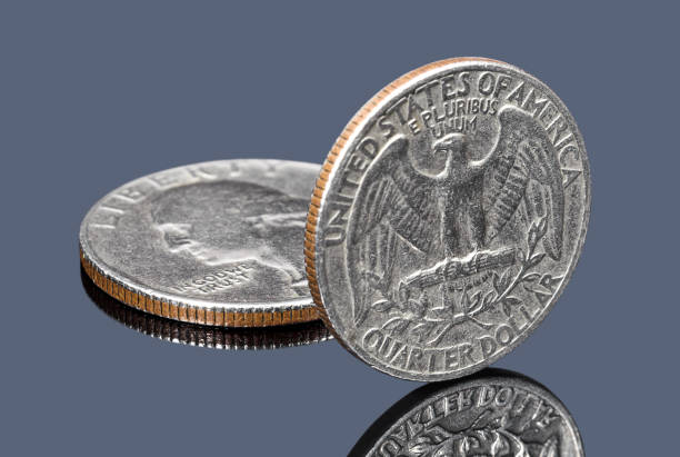 istock Quarter dollar coins on gray specular surface 1135140468