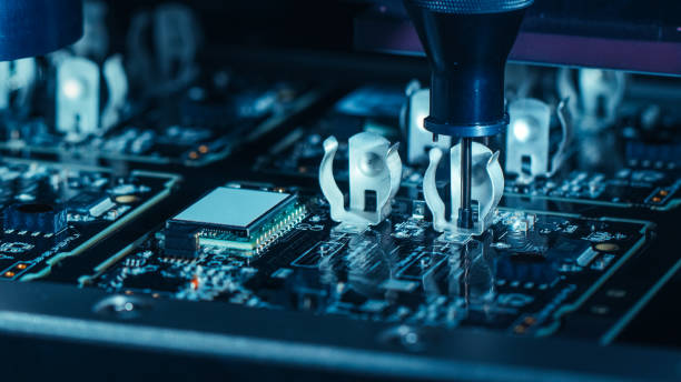 istock Close-up Macro Shot of Electronic Factory Machine at Work: Printed Circuit Board Being Assembled with Automated Robotic Arm, Pick and Place Technology Mounts Microchips to the Motherboard. 1135140507