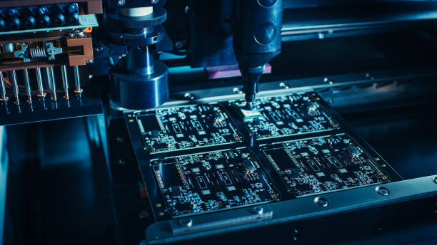 istock Factory Machinery at Work: Printed Circuit Board Being Assembled with Automated Robotic Arm, Surface Mounted Technology Connecting Microchips to the Motherboard. Macro Close-up. 1135140560