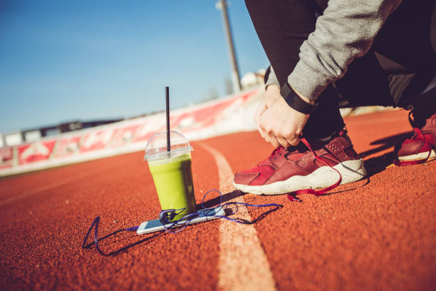 istock Woman tying shoelaces on stadium 1135142127