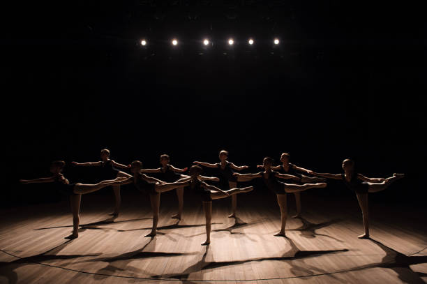 uma dança coreografada de um grupo de bailarinas consideravelmente novos graciosos que praticam no estágio em uma escola clássica do bailado - round bale - fotografias e filmes do acervo