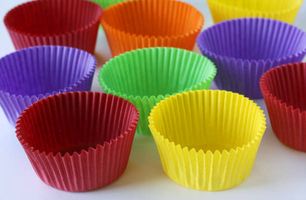 istock Colorful empty paper forms capsules for muffins and cupcakes on white background - baking dessert - close up on white background 1135143647