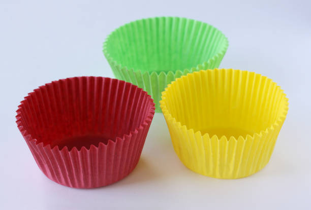istock Colorful empty paper forms capsules for muffins and cupcakes on white background - baking dessert - close up on white background 1135143755