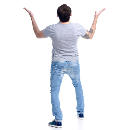 Man in jeans standing looks up, shock wow on white background isolation