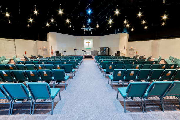 Empty Church Auditorium Horizontal shot of a church auditorium from the back facing toward the stage looking down the center aisle. place of worship stock pictures, royalty-free photos & images