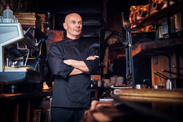 istock Confident chef posing with his arms crossed and looking away in a restaurant kitchen. 1135145899