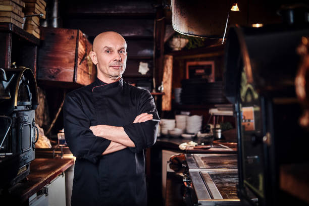 istock Confident chef posing with his arms crossed and looking at a camera in restaurant kitchen. 1135147666