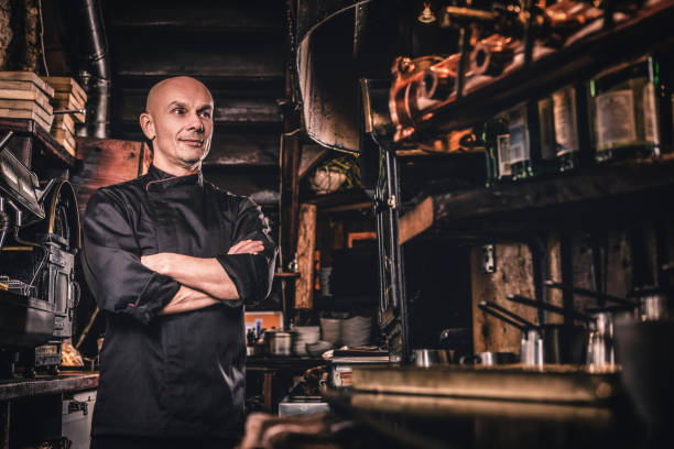 istock Confident chef posing with his arms crossed and looking away in a restaurant kitchen. 1135148033
