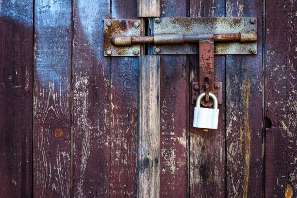 istock Old brown wooden plank door with padlock 1135148190