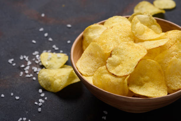 istock Crispy potato chips in bowl with salt 1135149272