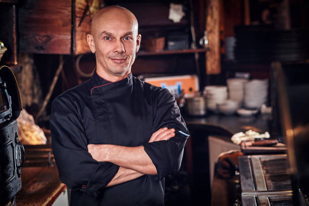 istock Confident chef posing with his arms crossed and looking at a camera in restaurant kitchen. 1135149320