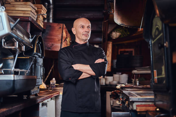 istock Confident chef posing with his arms crossed and looking away in a restaurant kitchen. 1135149386