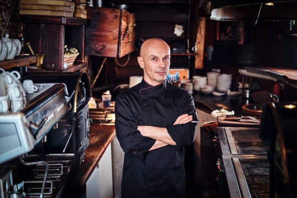istock Confident chef posing with his arms crossed and looking at a camera in restaurant kitchen. 1135151001