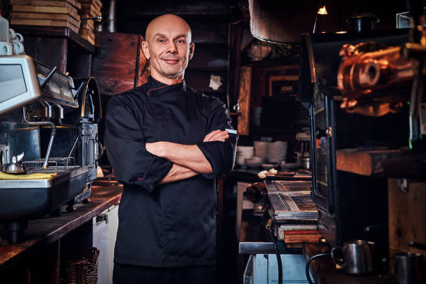 istock Confident chef posing with his arms crossed and looking at a camera in restaurant kitchen. 1135151437