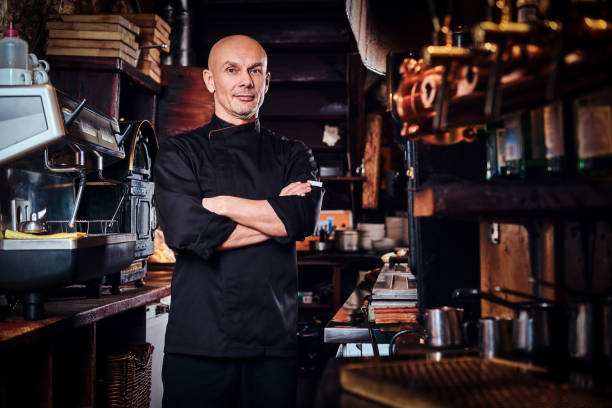istock Confident chef posing with his arms crossed and looking at a camera in restaurant kitchen. 1135151565