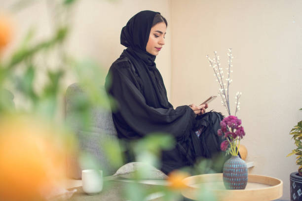 istock Beautiful arab woman using smart phone while resting on balcony 1135152172