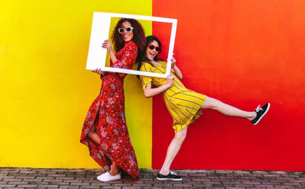 Photo of Girls posing with empty picture frame