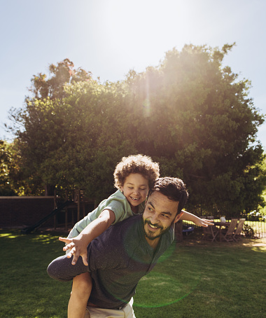 Loving Brazilian father playing with his son at the park and looking very happy - lifestyle concepts