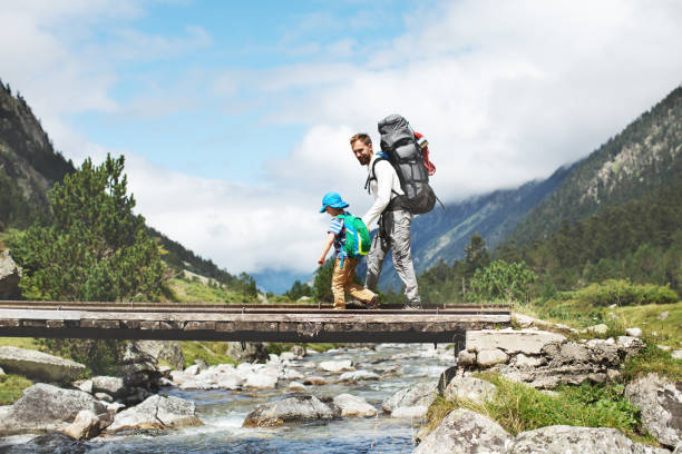 Father and son hiking together in mountains Father and son hiking together in mountains wilderness photos stock pictures, royalty-free photos & images