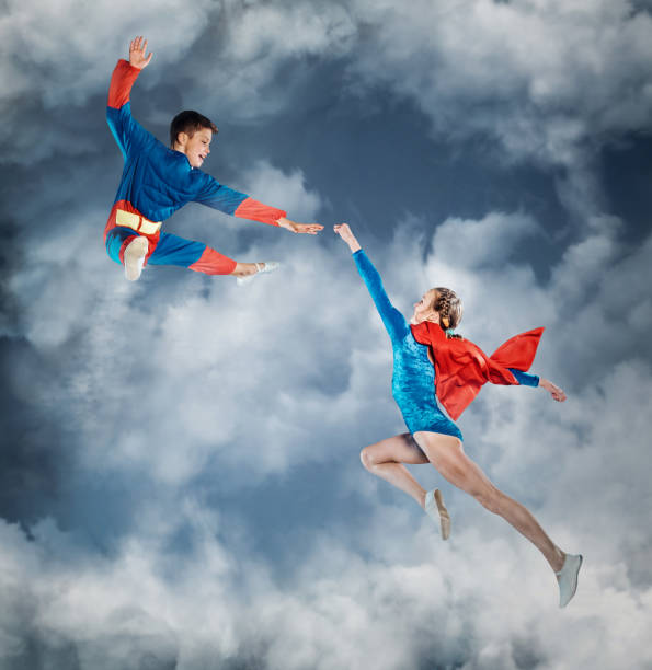 空を飛ぶ超人間の服の面白い子供たち。 - mask superhero heroes men ストックフォトと画像