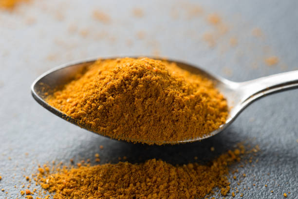 spoon of curry spice macro stock photo