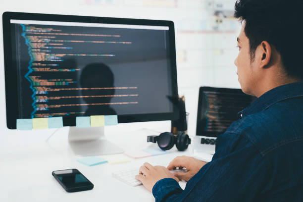 Programmers and developer teams are coding and developing software stock photo