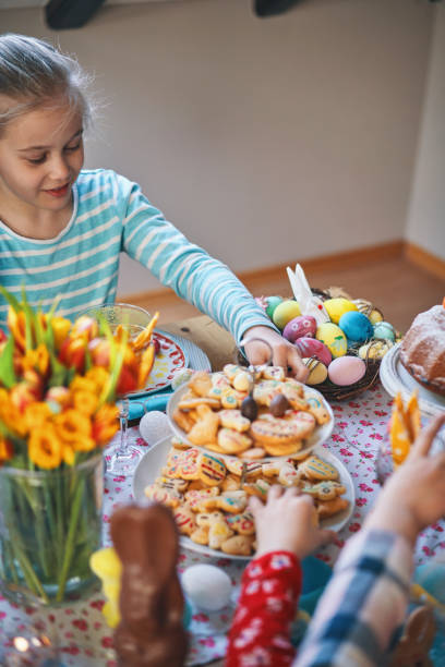 istock Cute Little Kids Having Fun and Eating Cookies on a Decorated Easter Table 1135158075