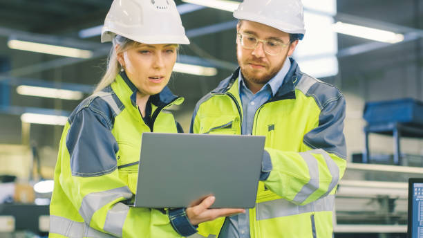 istock Inside the Manufacturing Factory Male Mechanical Engineer Works on Personal Computer Under Supervision of Female Chief Project Engineer. 1135159597