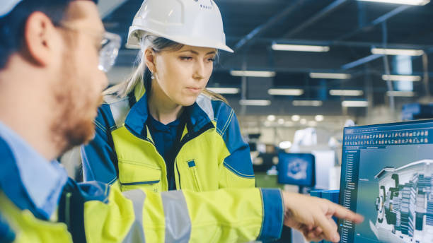 istock Inside Factory Male Mechanical Engineer and Female Chief Engineer Work Together on the Personal Computer, They Discuss Details of the 3D Engine Model Design. 1135159609