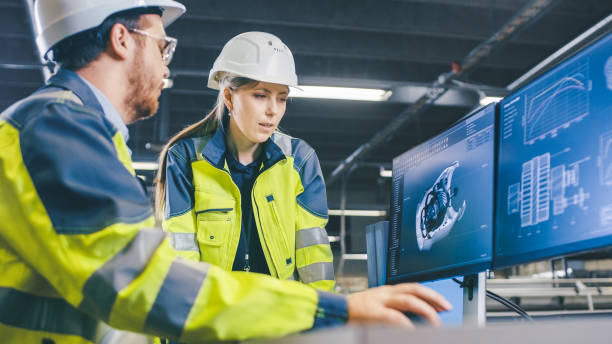 istock At the Factory: Male Mechanical Engineer and Female Chief Engineer Work Together on the Personal Computer, They Discuss Details of the 3D Engine Model Design. 1135159612
