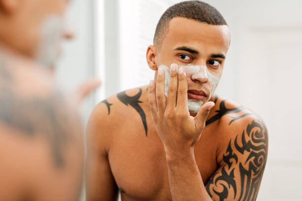 istock Young man applying anti-aging cream on his face 1135159915