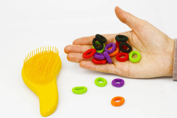 istock Yellow comb and hair ties in hand 1135160178