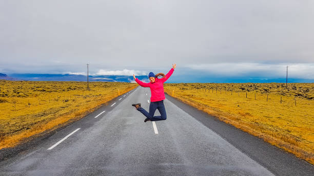 istock Iceland - Girl jumping on a road 1135163298