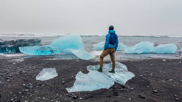 Iceland - Man standing on small ice bergs