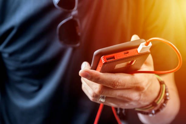 istock Man in black tshirt charging his smartphone with power bank, power unit. 1135165350