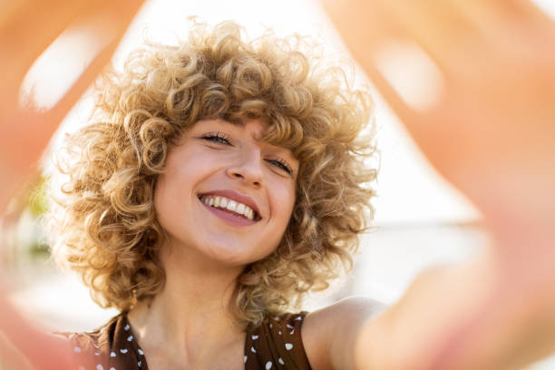 ritratto di giovane donna con i capelli ricci - blond hair fashion smiling attractive female foto e immagini stock