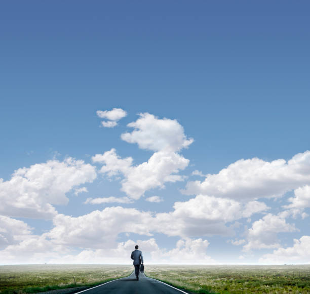 istock Businessman Walks Down Long Road Toward The Horizon 1135166389