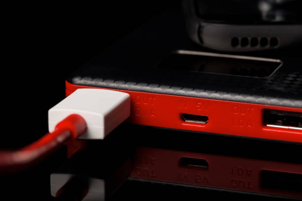 black and red power bank charger with two exit on black glass surface - recharger imagens e fotografias de stock