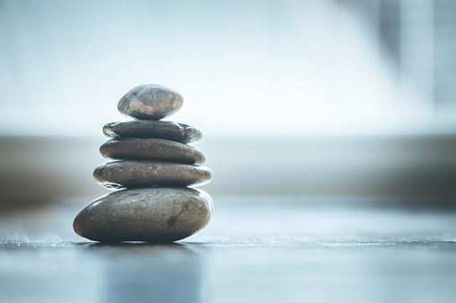 Feng Shui: Stone cairn on the wooden floor, text space and cool light