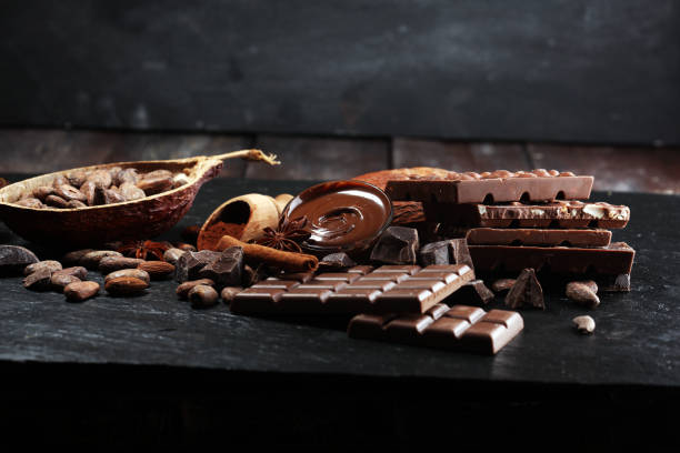 istock Melting chocolate or melted chocolate with a chocolate swirl and stack, chips and powder on black 1135168334