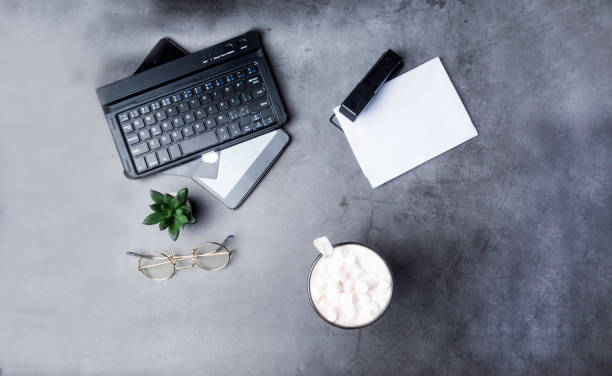 istock white papper glasses, cacus, notepad, stapler credit card, cup of cofee on gray background 1135169810